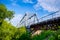 Beautiful railway bridge on a background of greenery and blue sky, perspective