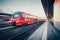 Beautiful railway station with modern red commuter train in motion