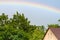 Beautiful rainbow over the roofs, house in summer