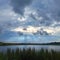 Beautiful rainy clouds in the dramatic sky over the lake