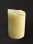 Beautiful and realistic natural color candle front view isolated on black background. Wax candle burning on black background,