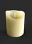 Beautiful and realistic natural color candle front view isolated on black background. Wax candle burning on black background,