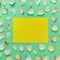 Beautiful rectangular pattern of pink and yellow rose petals and leaves on green paper background. Copy space for your text