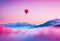 Beautiful red air balloon heart shape against blue and pink pastel sky in a sunny bright morning