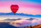 Beautiful red air balloon heart shape against blue and pink pastel sky in a sunny bright morning