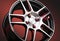 beautiful red alloy wheels close-up, sporty style wheel nuts in red on a black gradient background auto parts