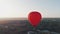 A beautiful red balloon flies in the morning over the river and the city