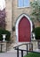 Beautiful red church door framed by flowering trees, spring time, Galena, IL.