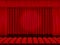 Beautiful red cinema hall with seats facing red folded curtain drapes on a black stage vector