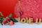 A beautiful red and gold candy box on a white table with a red background. Cork letters spell the words love u for Valentine`s Da