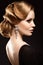 Beautiful red-haired girl in a black dress with a smooth evening haircut in the form of waves and bright makeup. Beauty face.