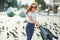 Beautiful red-haired girl having fun on the street. The girls have a beautiful figure, a white T-shirt and jeans with sunglasses