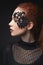 Beautiful red-haired girl lace makeup in the dark