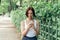 Beautiful red-haired girl pensively prints a message while walking in the park