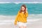 Beautiful red haired teenage girl walking on the ocean coast