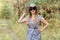 Beautiful red-haired woman of fifty years in the hat with sunglasses in the woods during the summer