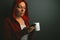 Beautiful red hooded woman drinking coffee and sending text mess