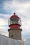 Beautiful red lighthouse rising up in blue sky