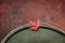 Beautiful red maple leaf on the edge of a tin bucket with water on autumn background. Space for text, top view.