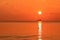 Beautiful red orange sunrise above the sea and clouds with a ship crossing the reflected in the water sun path