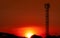 Beautiful red and orange sunset sky. Silhouette telecommunication tower and  tree in the evening with beautiful red sunset sky