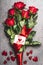 Beautiful red roses bouquet with loop and greeting card with heart and handwritten lettering for you, top view. Love symbol