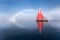 Beautiful red sailboat under a glowing fog bow.