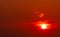 Beautiful red sun at sunset. Red sunset sky. The sun is obscured by some clouds at sunset. Big sun in the evening. Blood sky. Heat