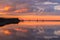 Beautiful red sunset in the lake reflection of red twilights and clouds on the lake rays and sunlight on the calm lake