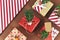 Beautiful red, white and natural brown decorated Christmas gift boxes with ribbons and fir branches on brown backgroun