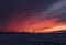 Beautiful red winter sunset in snowed field