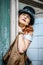 Beautiful redhair steampunk girl with goggles on black hat outside toilet background. Old-fashioned