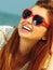 Beautiful redhaired girl in sunglasses on beach, portrait