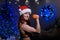 Beautiful redhead athlete in a Santa Claus hat is doing biceps exercises. Fitness woman in sportswear is holding