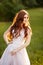 Beautiful redhead Bride in fantastic wedding dress in blooming garden.