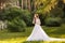 Beautiful redhead Bride in fantastic wedding dress in blooming garden.