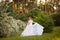 Beautiful redhead Bride in fantastic wedding dress in blooming garden.