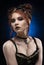 A beautiful redhead cosplayer girl wearing a Victorian-style steampunk costume with big breasts in a deep neckline. Portrait. Blue