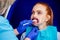 Beautiful redhead ginger woman with open mouth and mouthpiece at the dentist wearing plastic whitening tray