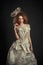 Beautiful redhead girl in elegant paper dress. Sensual image with bright makeup. Beauty model