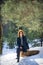 Beautiful redhead girl has a rest on the wooden log in winter