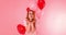 Beautiful redhead girl with red heart balloon posing. Happy Valentine`s Day concept.