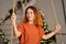 A beautiful redhead girl is swinging in her room on Christmas night