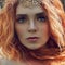 Beautiful redhead Norwegian girl with big eyes and freckles on face in the forest. Portrait of redhead woman closeup in nature