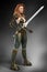 Beautiful redhead woman assassin warrior holding a sword