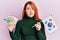 Beautiful redhead woman holding south korean won banknotes and flag skeptic and nervous, frowning upset because of problem