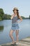 Beautiful redhead woman poses near water in denim skirt