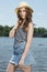 Beautiful redhead woman poses near water in denim skirt