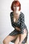 Beautiful redhead woman on a stool