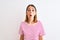 Beautiful redhead woman wearing casual striped pink t-shirt over isolated background afraid and shocked with surprise expression,